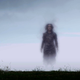 An otherworldly woman emerges from the mist behind a fence and a picnic table.